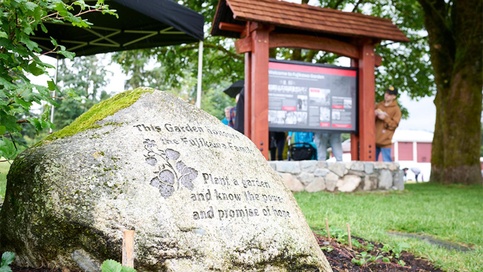Fujikawa Family Garden stone marker with an inspiring message amidst greenery.
