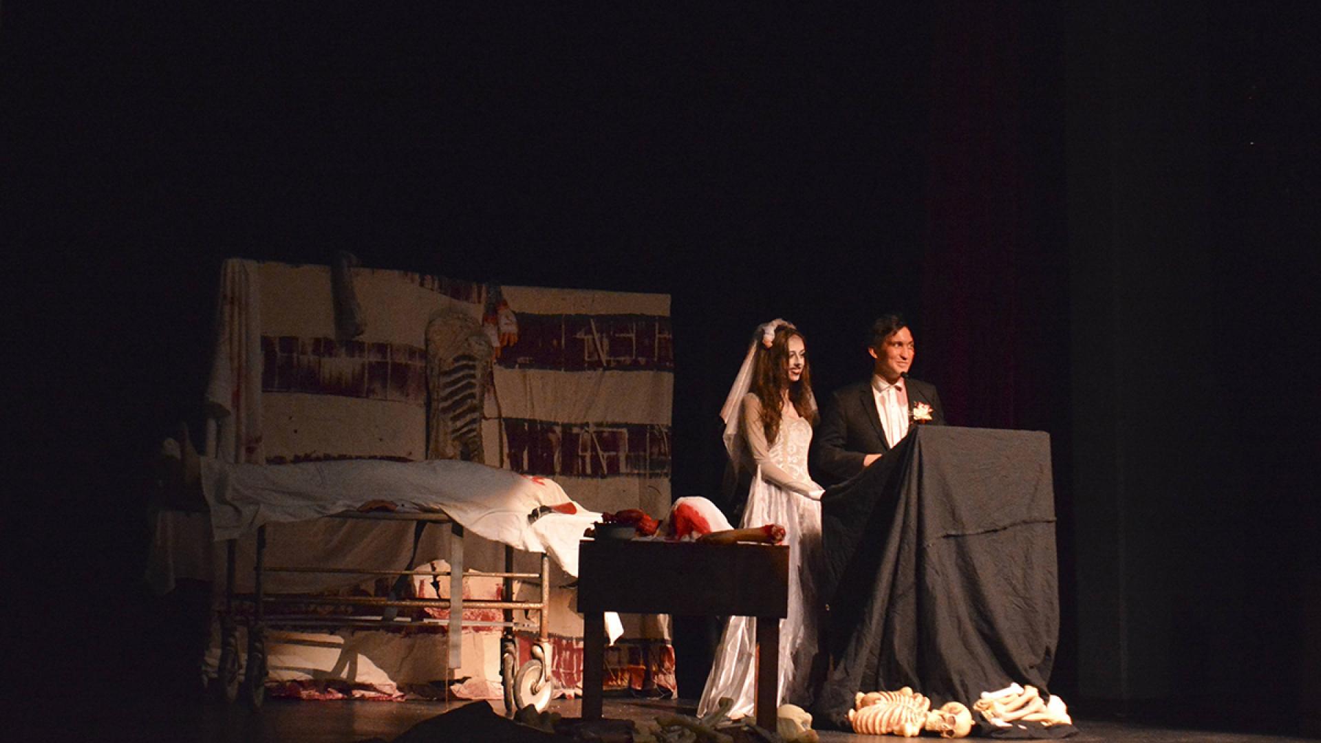 Last year performances hosts making announcement at theatre podium in scary costume