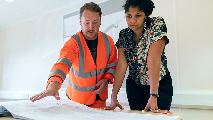 Two people reviewing building plans.