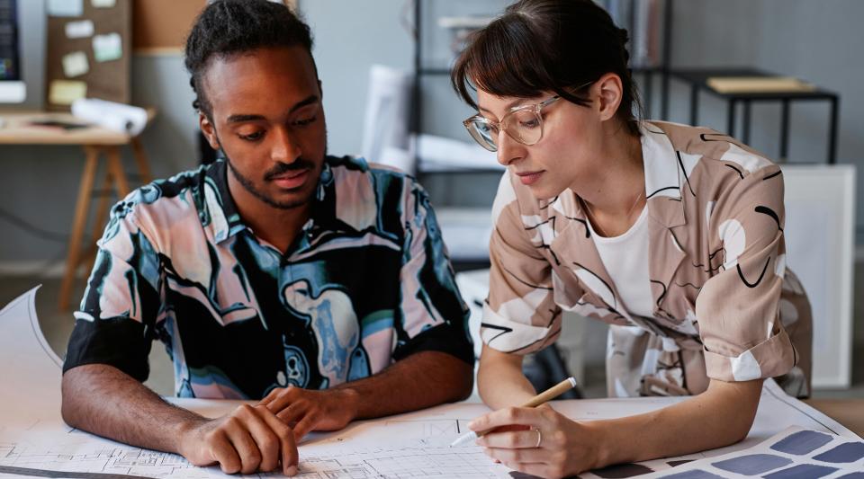 Two designers looking a building plans