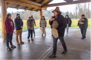 group of people surrounding an indigenous drummer