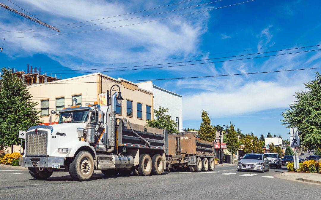 A heavy truck driving down First Avenue on a sunny day